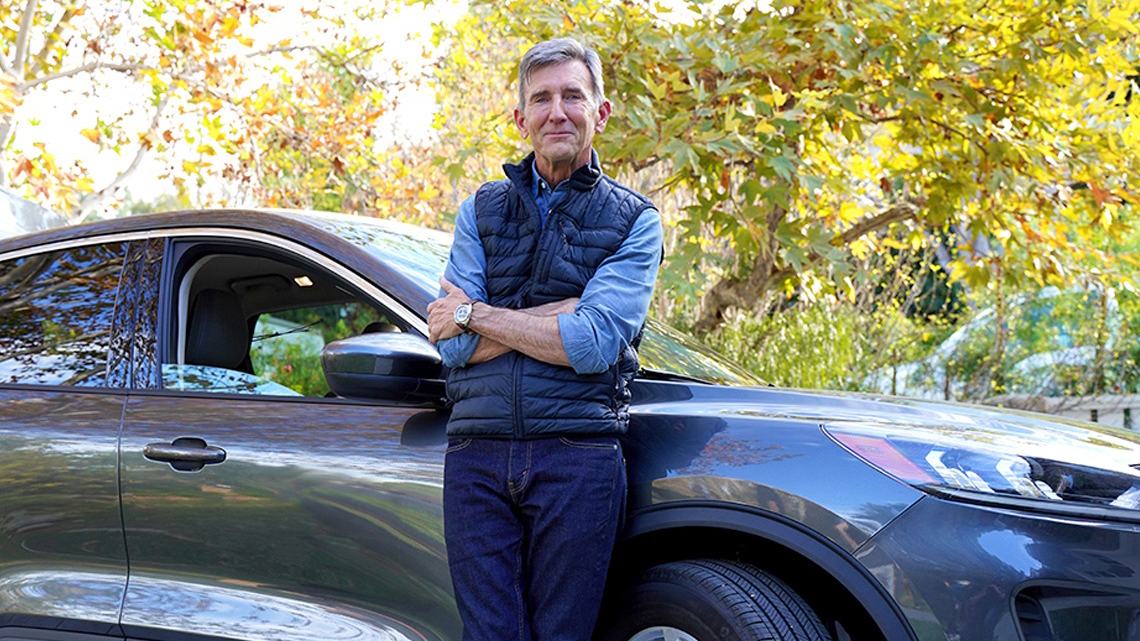 AARP Auto Insurance Program from The Hartford Man leaning against blue car