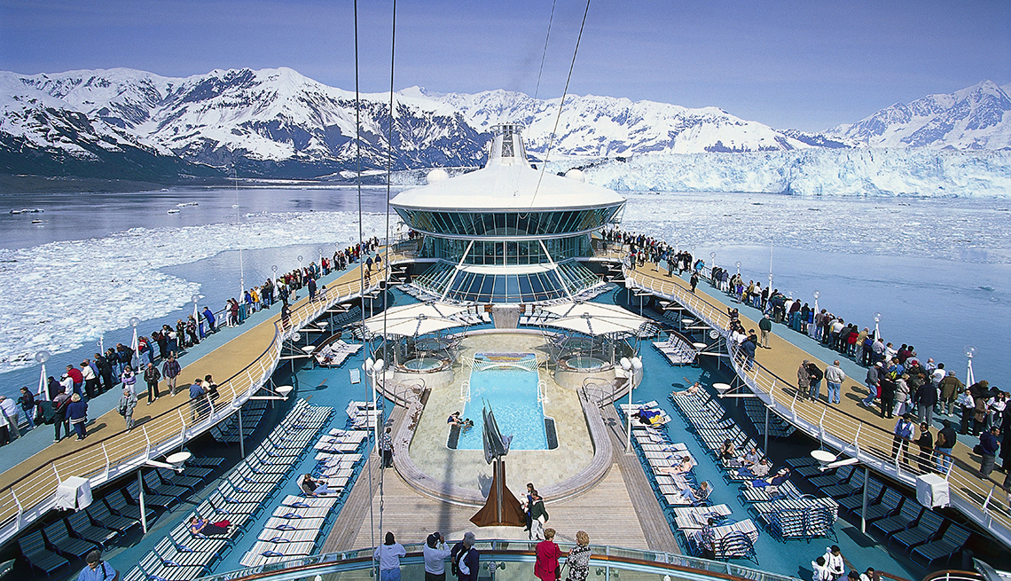 View of deck of cruise ship with snowy mountains in the distance