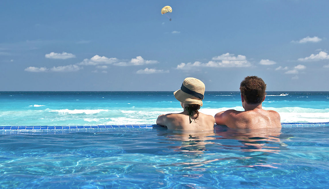 Couple Lounges In An Infinity Pool Overlooking The Ocean At Resort In Caribbean, Best Honeymoon Destinations