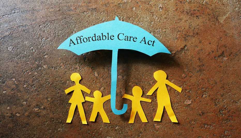 a paper family is under a blue umbrella