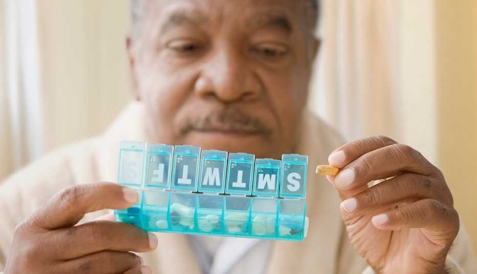Man looking at pills