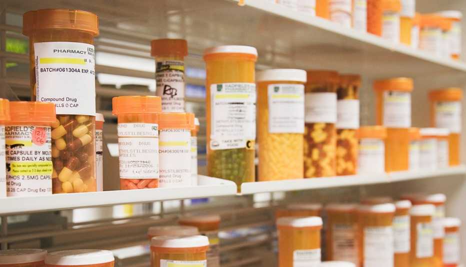 rows of prescription pill bottles on a pharmacy shelf