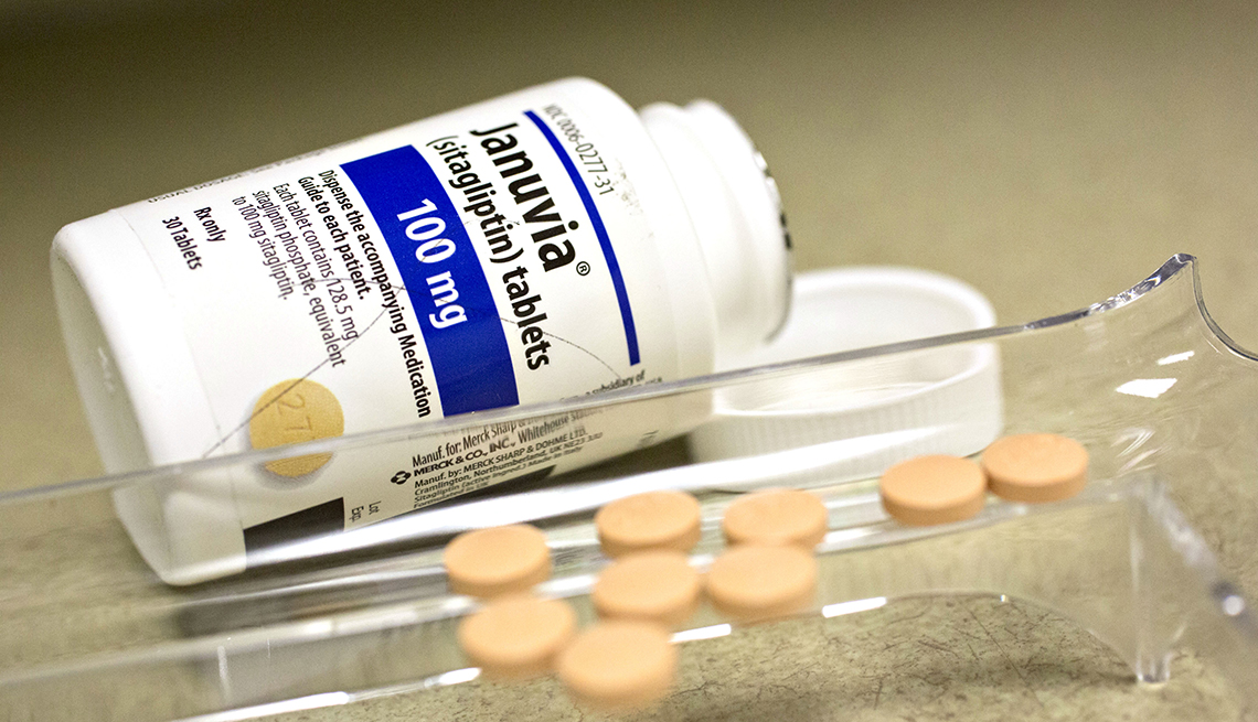 a white bottle of januvia with pills sitting next to it