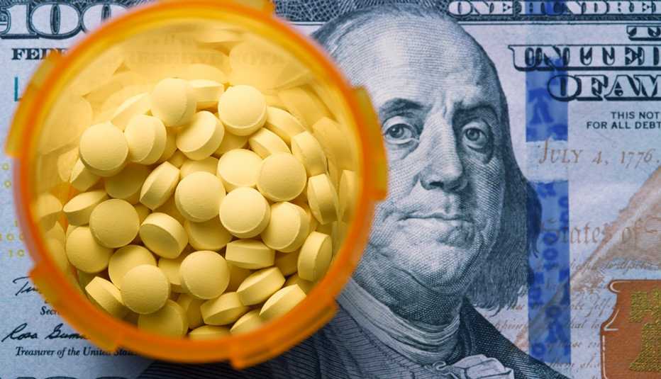 Bottle of pills sitting on top of a one hundred dollar bill