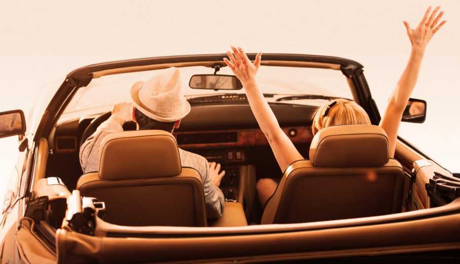 couple driving in an retro convertible car
