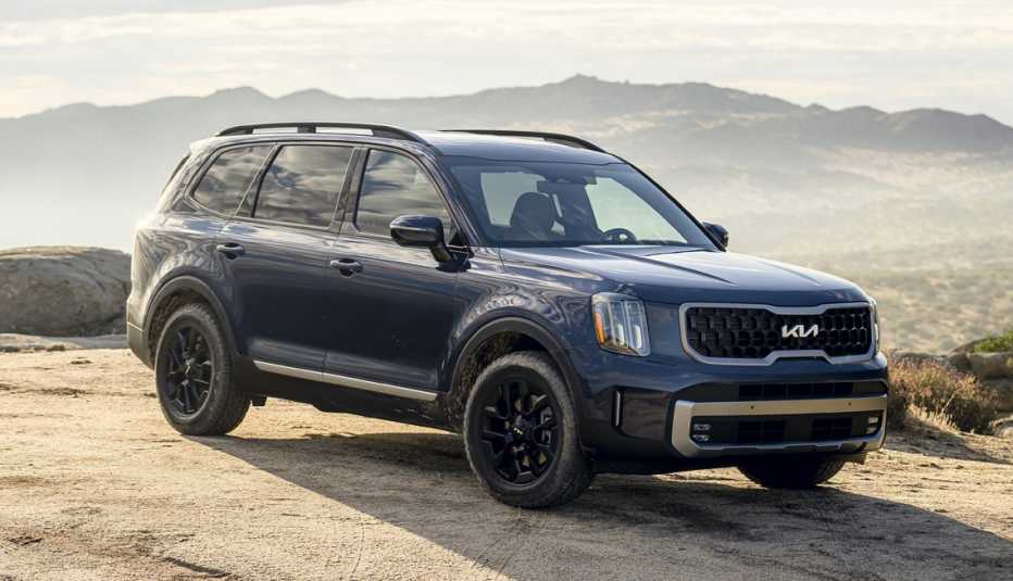 a twenty twenty three kia telluride parked on a cliff overlooking mountains