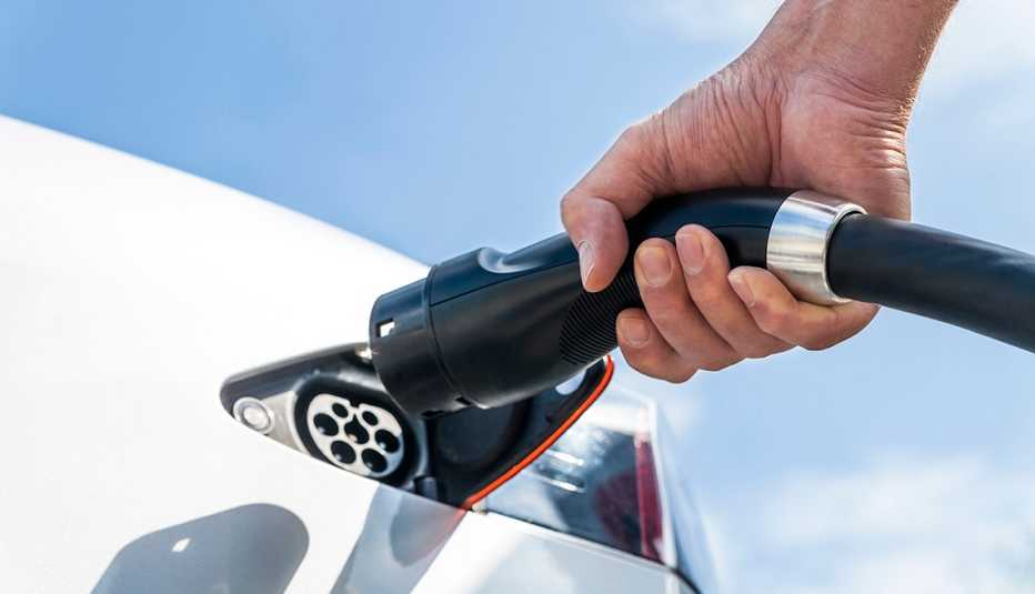 a man holds an electric charger as he prepares to charge his vehicle