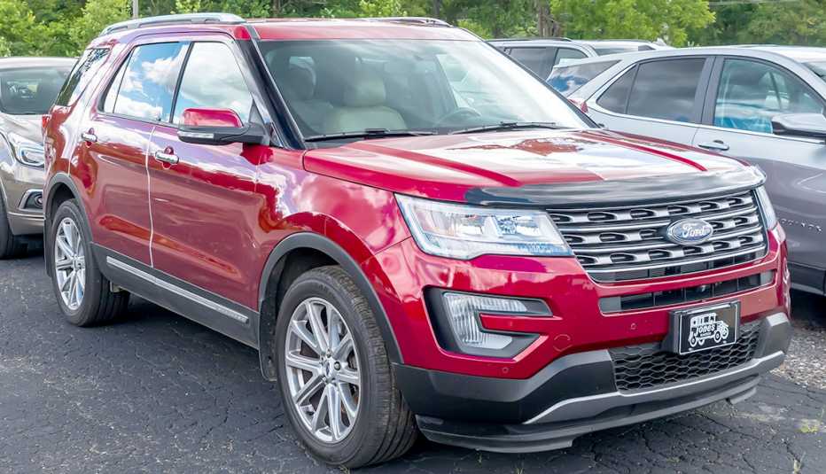 a red twenty seventeen ford explorer sits on a used car dealer lot there is a january twenty twenty four recall on models from twenty eleven to twenty nineteen