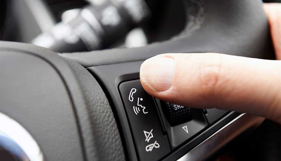 Close Up Of Hand Pressing Car Bluetooth Control On Steering Wheel