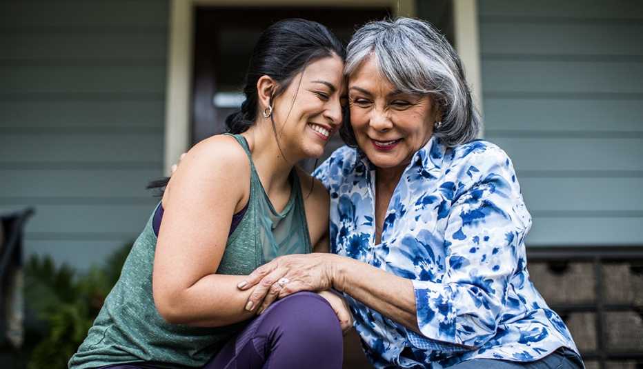 Woman and adult daughter laughing on porch