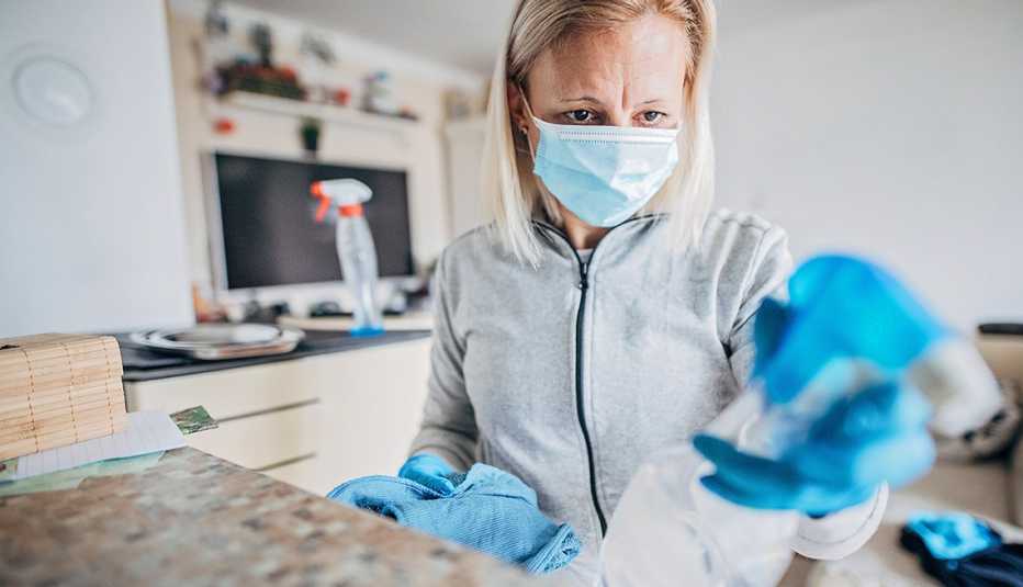 One mature woman cleaning and doing disinfection on all surfaces in her house.