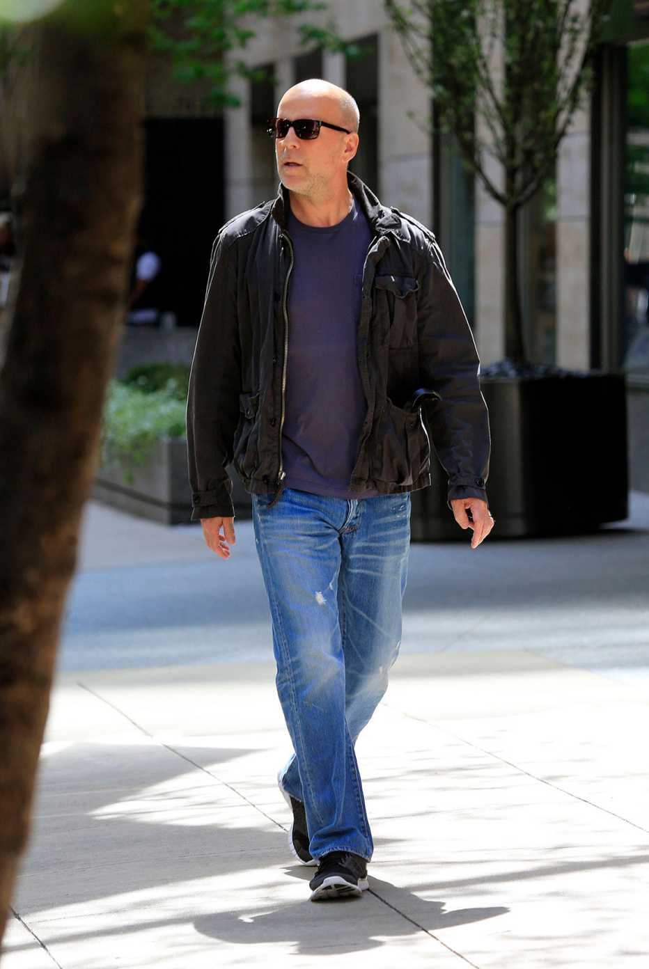 Bruce Willis in distressed jeans with sneakers and tees and leather jacket