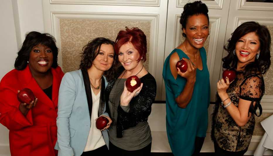 julie chen moonves with other hosts from the talk, each holding an apple