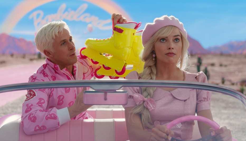 ryan gosling holding a pair of roller blades next to margot robbie in the driver's seat of a car in the film barbie