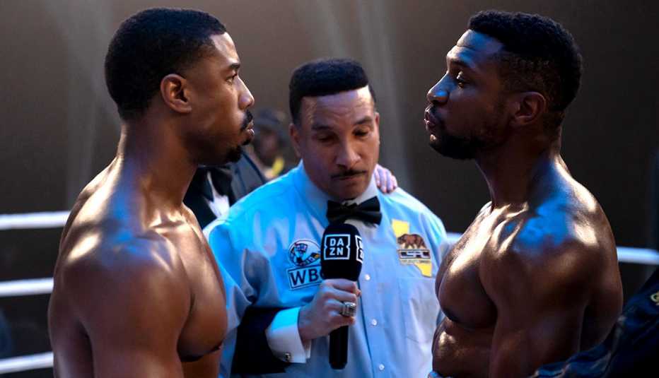 michael b jordan as adonis creed, tony weeks as referee and jonathan majors as damian anderson in a boxing ring in still from creed three
