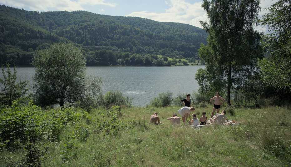people in grass next to body of water