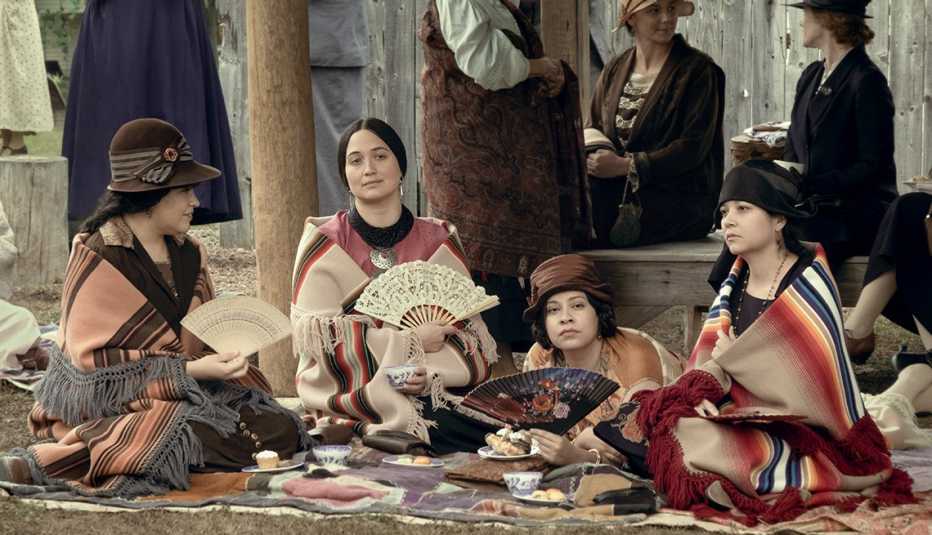 janae collins lily gladston cara jade myers and jillian dion sitting on the ground in a scene from the film killers of the flower moon