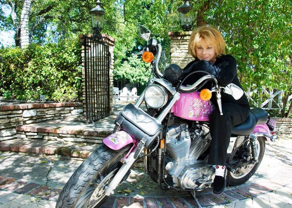 Ann Margret sitting on a pink and black Harley Davidson motorcycle for her album Born to Be Wild