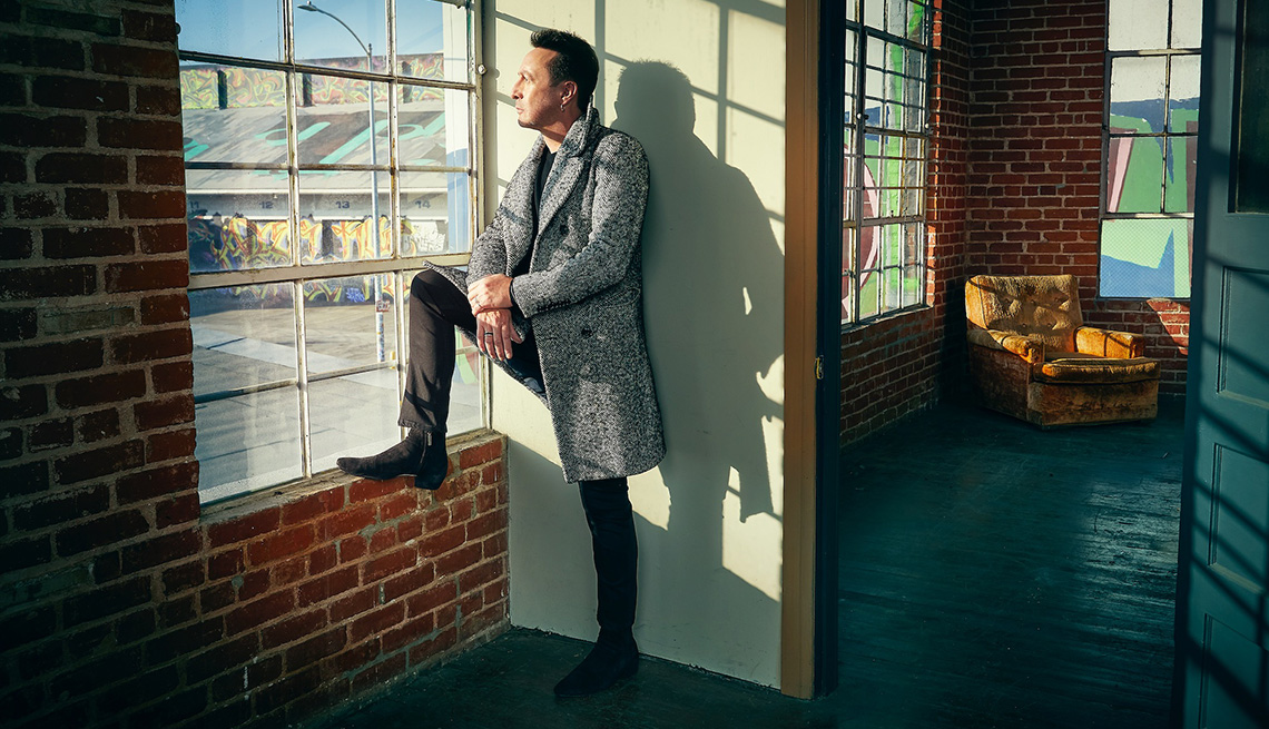 Musician Julian Lennon looking through a window
