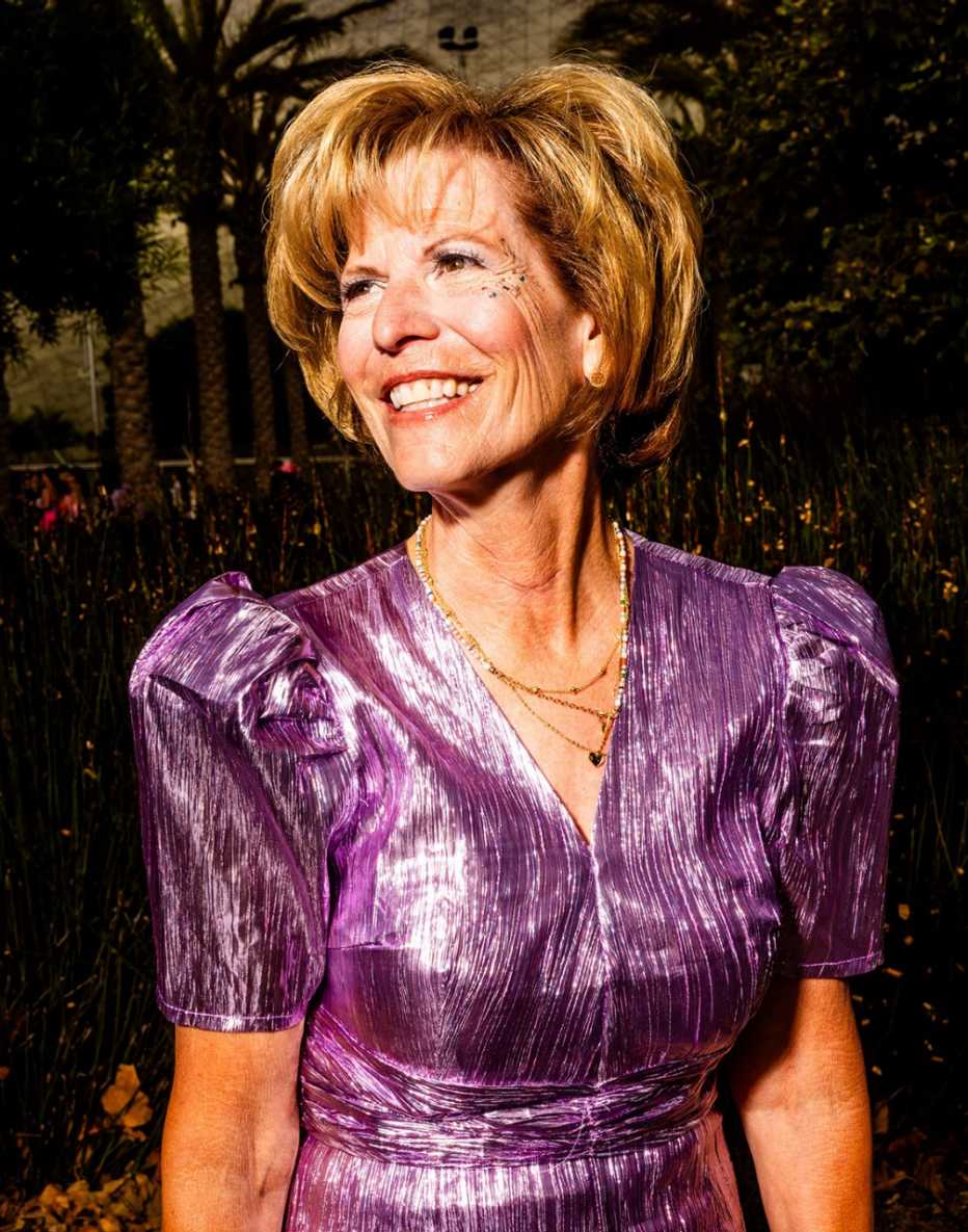 debbie holt poses in a metallic purple dress outside of sofi stadium in los angeles california