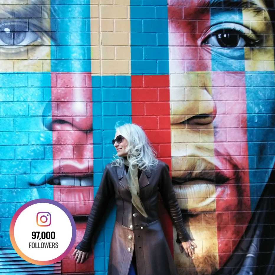 Dian Griesel standing in front of a colorful wall