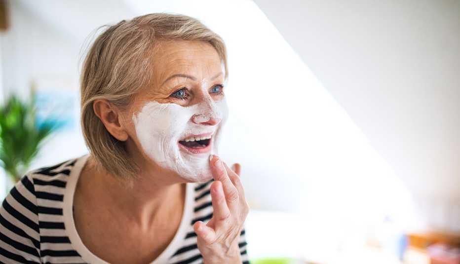 A woman applying face cream
