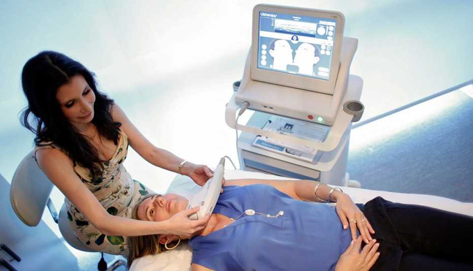 A doctor demonstrates Ultherapy procedure on a woman
