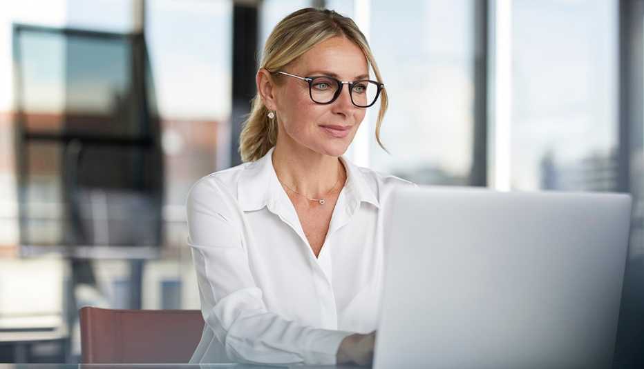 A woman using a laptop while working in an office