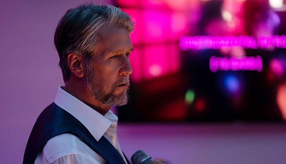 alan ruck holding a microphone in a scene from the hbo series succession