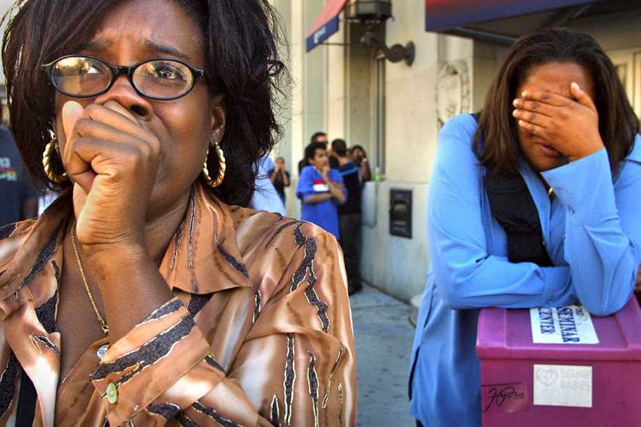two women react in new york city on september eleventh one is covering her mouth in horror and the other covering her eyes