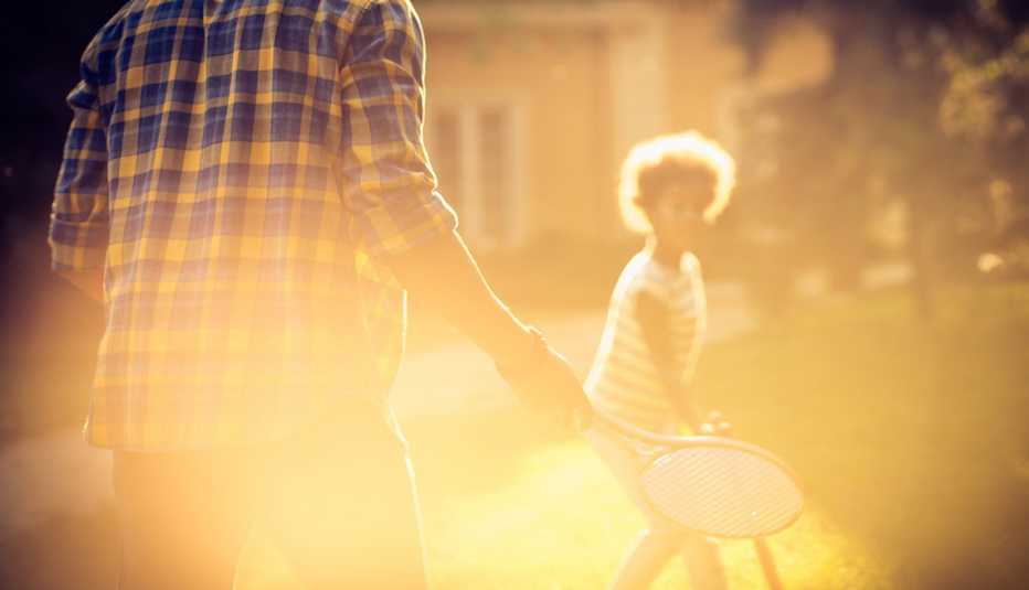 dreamy sunlight scene of a man and girl playing with badminton rackets