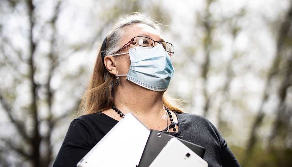teresa jenna wears a mask and looks upwards