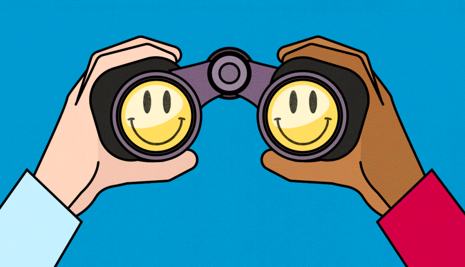 two hands hold onto a pair of binoculars with smiley faces