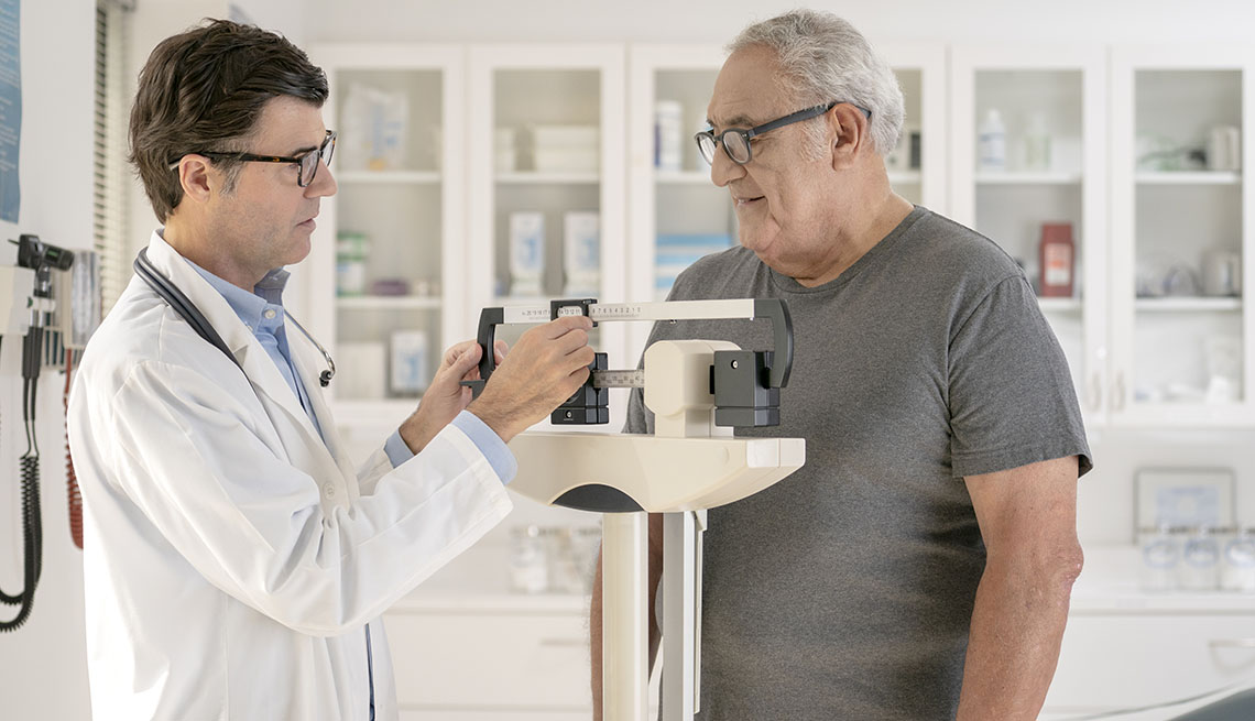 Doctor weighs man on scale