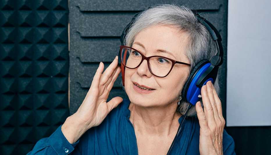 a woman wearing large blue headphones undergoing a hearing test at a hearing clinic for tinnitus