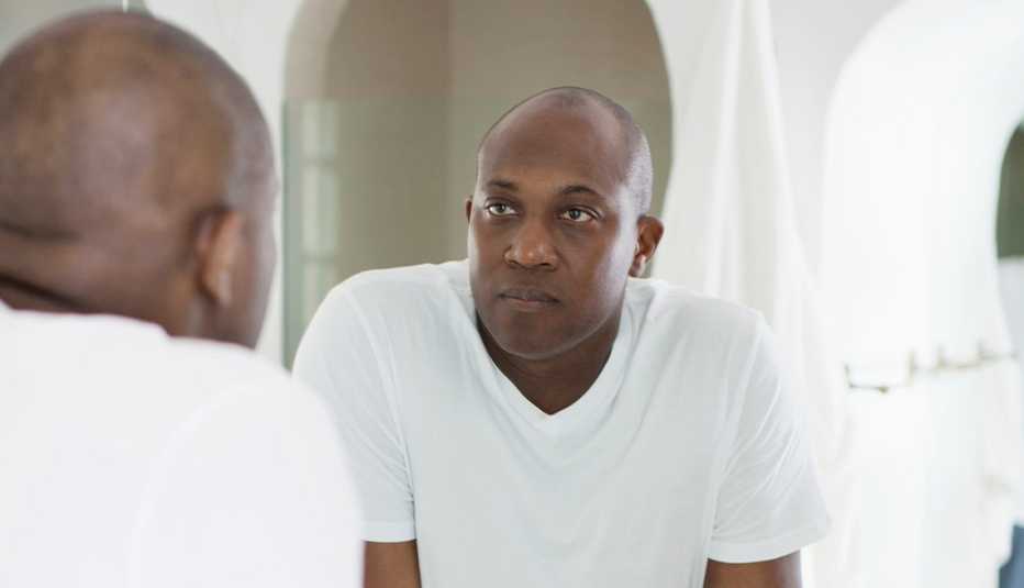 man looking in the mirror with determination