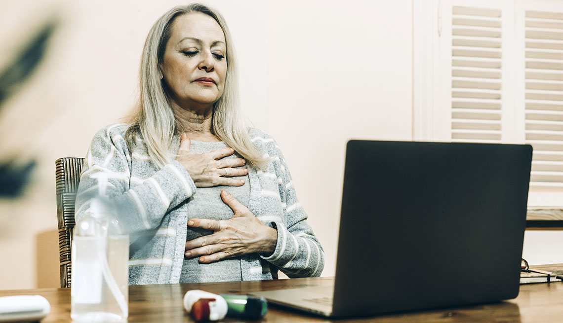 woman sitting at a table holding her breath
