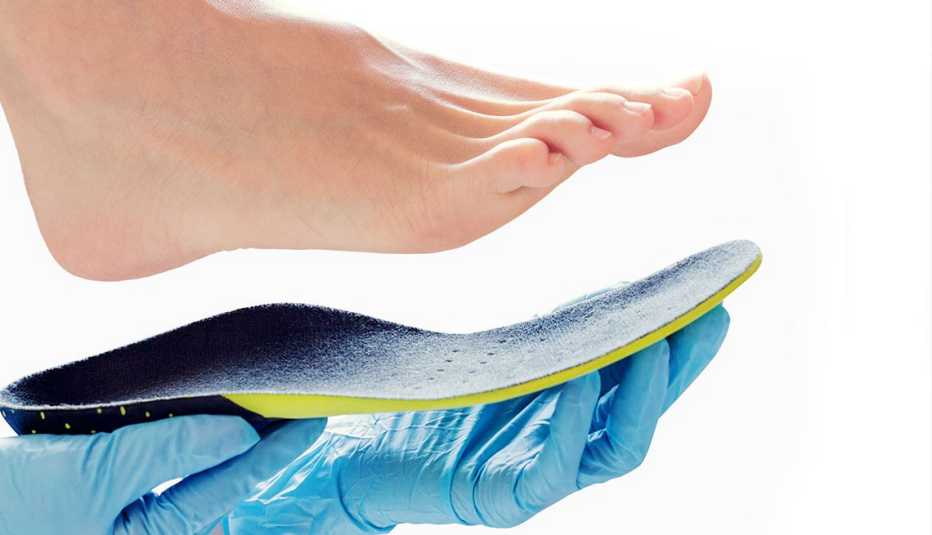 Hands in rubber gloves hold an orthopedic insole