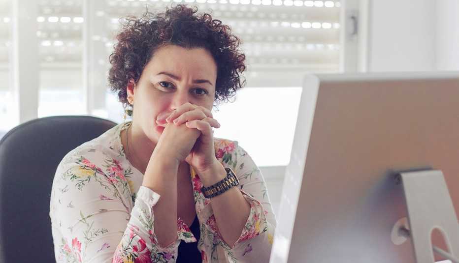 woman sitting at her desk, looking concerned