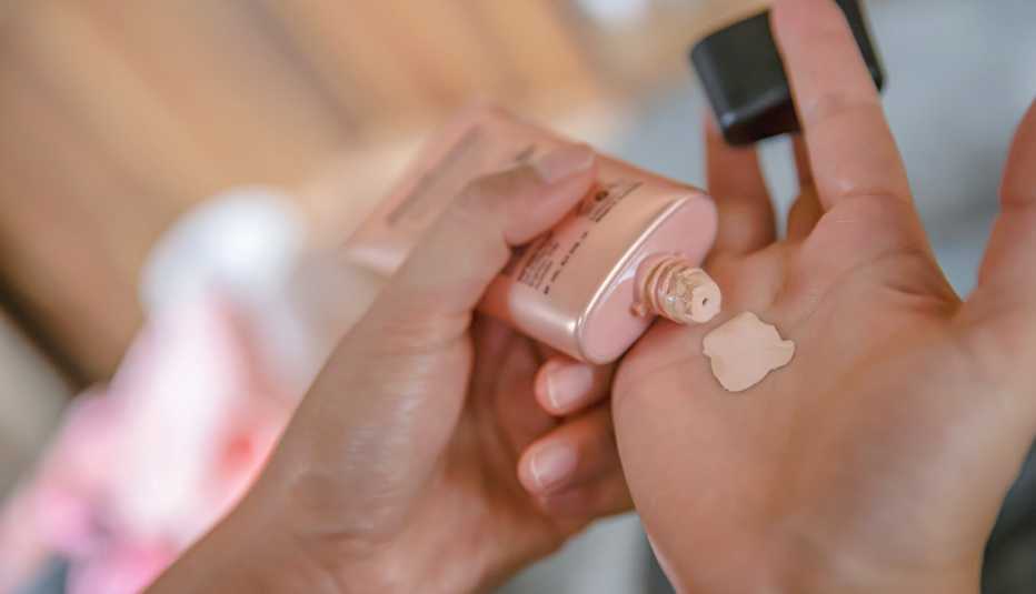 woman squeezing foundation makeup on her hand