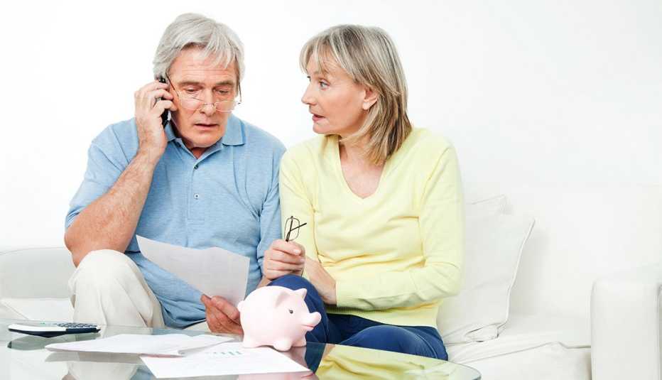 An older couple sits on the couch