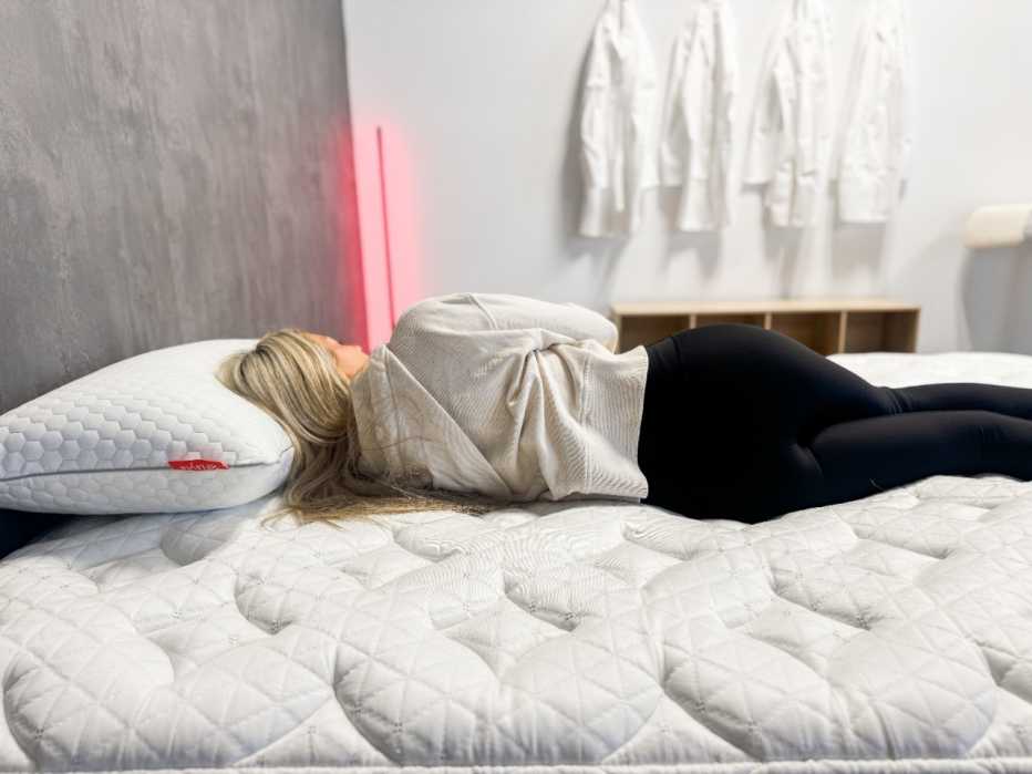 Woman lying on her side on the Helix Midnight mattress.