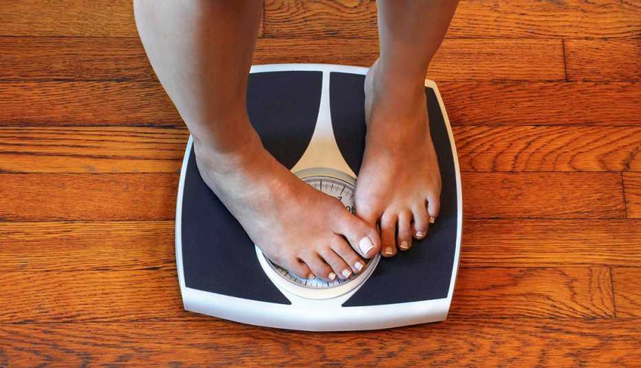 person standing on scale with their feet covering the reader so they cant see their weight