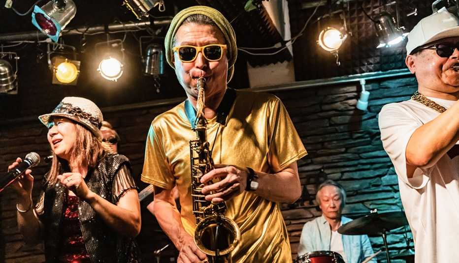 closeup of  part of a funk band onstage with a singer and horn section and drummer in backgroudn