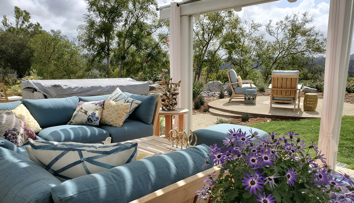 an outdoor covered patio with seating and curtains
