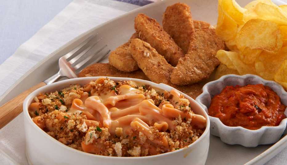 restaurant serving of plant based mac and cheese and fried chicken fingers
