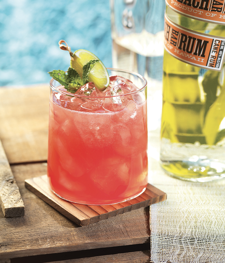 Mojito drink with a rum bottle in the background