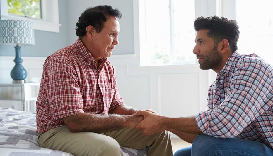Adult son comforting father suffering with dementia