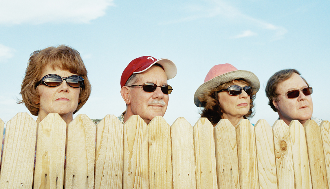 A group of neighbors looking over a fence.