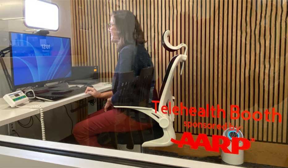 A woman uses a telehealth booth sponsored by AARP